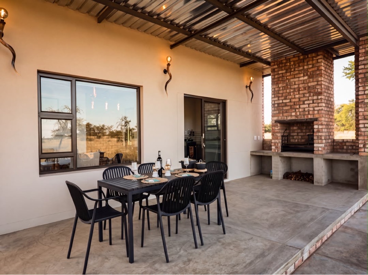The chalet patio at Zania Farm with outdoor dining and a built-in brick braai